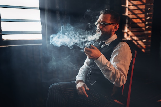 Foto retrato de hombre sentado en una silla y pipa