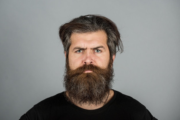 Retrato de hombre serio confiado tiene barba y bigote se ve seriamente aislado tipo hipster con l