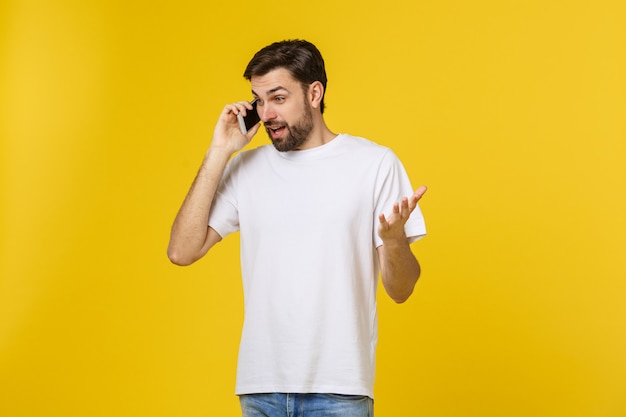 Retrato de un hombre serio hablando por teléfono aislado.