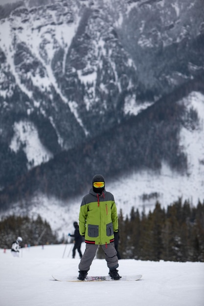 Retrato de hombre snowboarder en pista de esquí