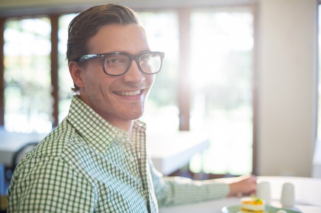 Retrato de hombre sonriente almorzando