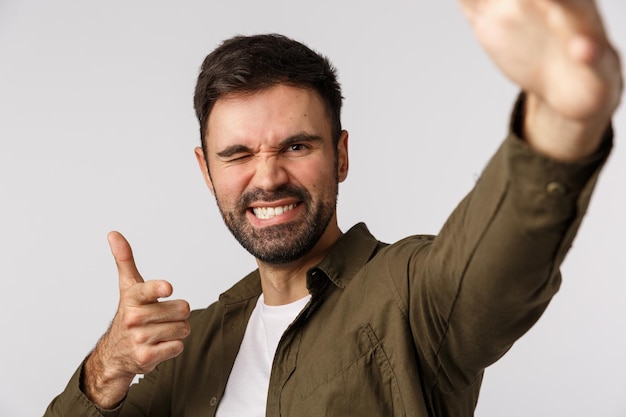 Retrato de un hombre sonriente con los brazos levantados contra un fondo blanco