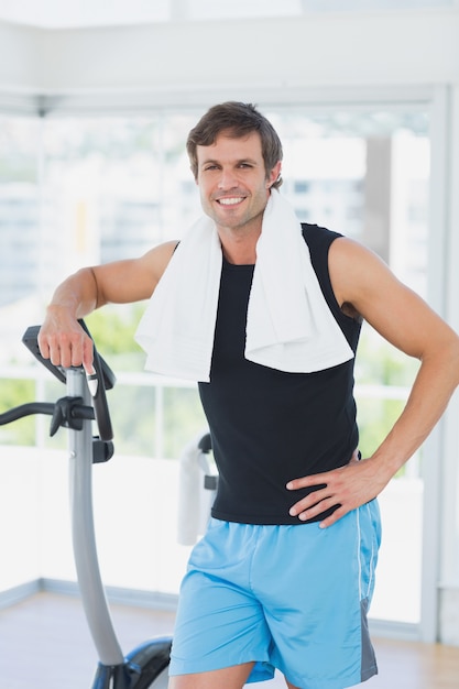 Retrato de un hombre sonriente en clase de spinning en gimnasio brillante