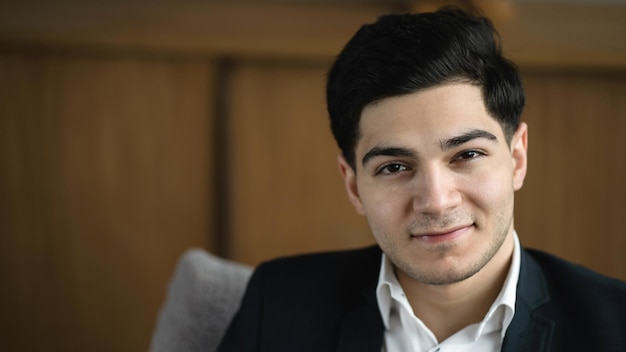 Retrato de un hombre sonriente economista en un traje formal sentado en una silla de oficina