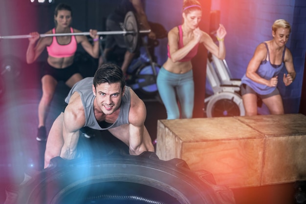 Foto retrato, de, hombre sonriente, elevación, neumático, en, gimnasio