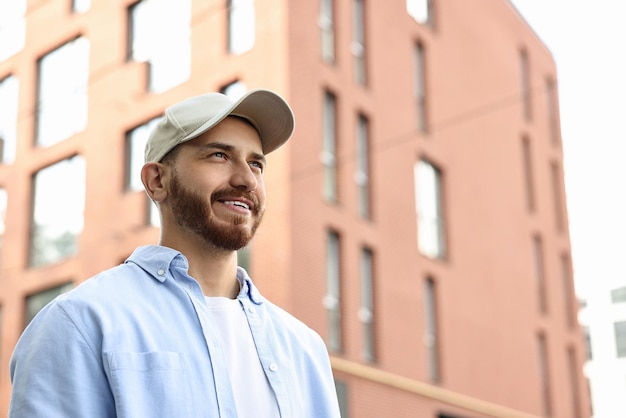 Retrato de un hombre sonriente con gorra de béisbol al aire libre Espacio para el texto