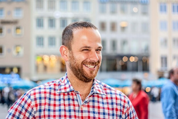 Retrato de un hombre sonriente guiñando el ojo en la ciudad