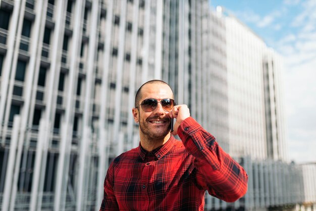 Retrato de un hombre sonriente de pie contra un edificio moderno