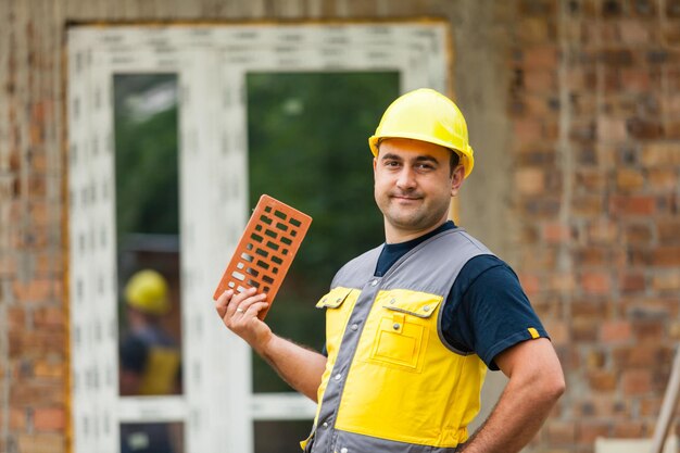 Foto retrato de un hombre sonriente de pie contra una estructura construida