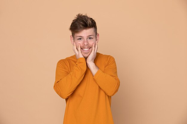 Foto retrato de un hombre sonriente de pie contra un fondo amarillo