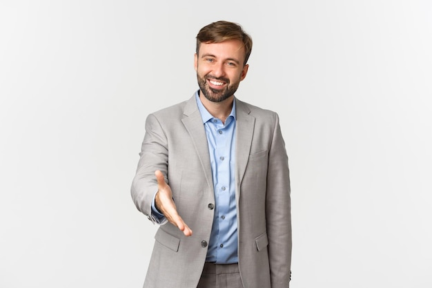Foto retrato de un hombre sonriente de pie contra un fondo blanco
