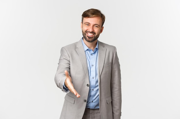 Retrato de un hombre sonriente de pie contra un fondo blanco