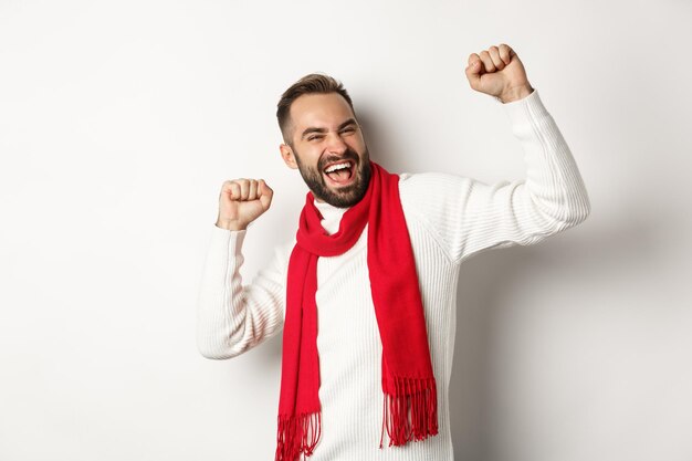 Foto retrato de un hombre sonriente de pie contra un fondo blanco