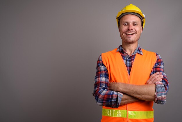 Foto retrato de un hombre sonriente de pie contra un fondo gris