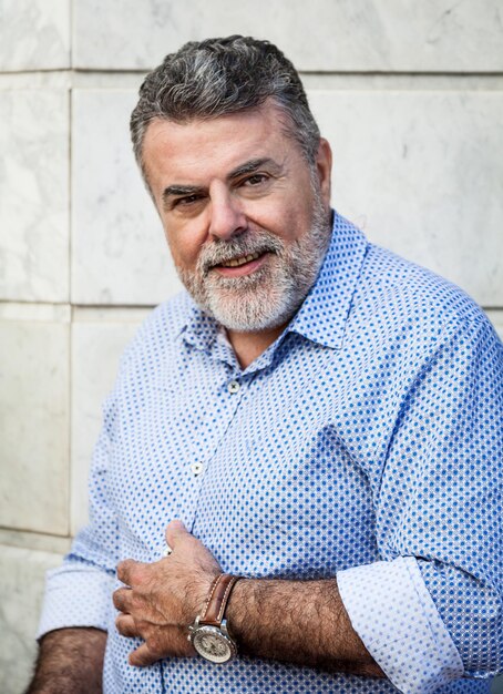 Foto retrato de un hombre sonriente de pie contra la pared