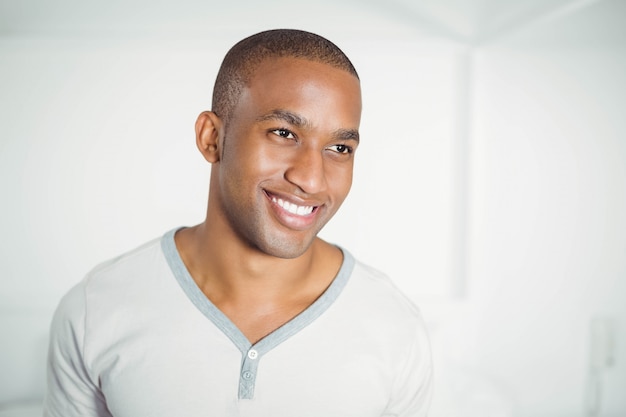 Retrato del hombre sonriente que se coloca y que mira lejos