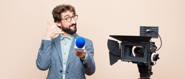 Foto retrato de un hombre y su cámara sobre un fondo crema