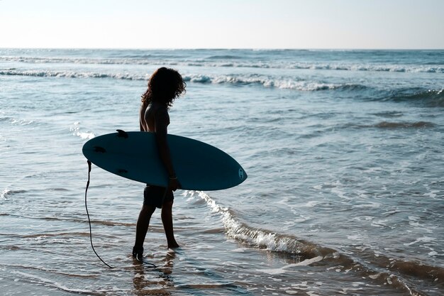 Retrato de hombre surfista con tabla de surf en la playa