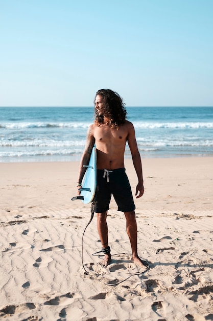 Retrato de hombre surfista con tabla de surf en la playa