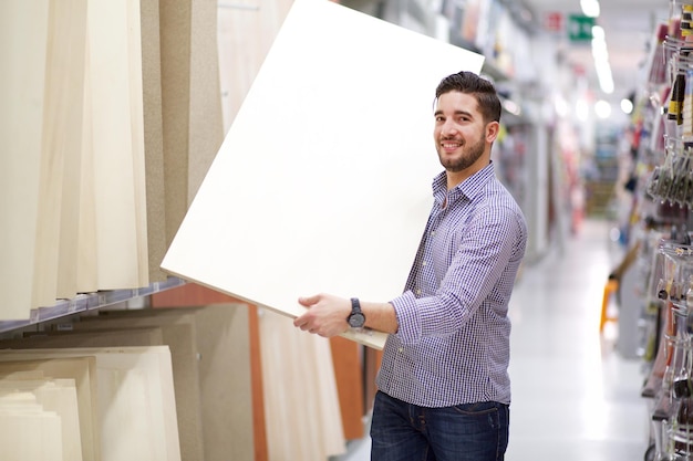 Foto retrato de un hombre con una tabla de madera en la tienda