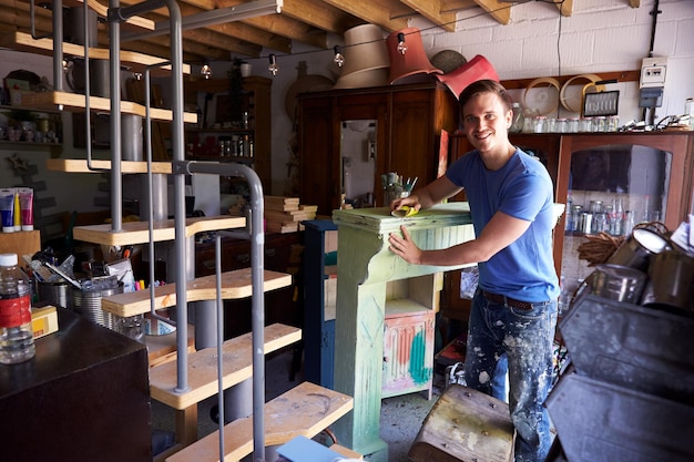 Retrato del hombre en el taller de reciclaje y trabajo en envolvente de fuego