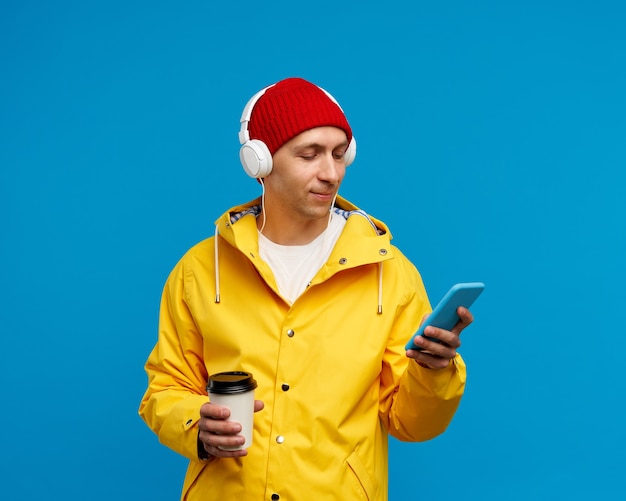 Retrato de hombre con teléfono escuchando música y tomando café