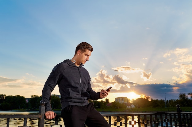 Foto retrato de un hombre toma un descanso de correr, hablar por teléfono, jogging