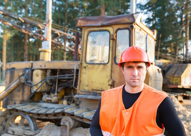 Retrato de hombre trabajando en casco sobre bulldozer