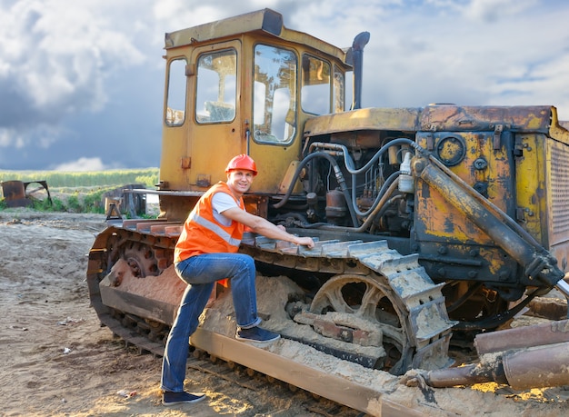 Retrato de hombre trabajando en un casco sobre excavadora