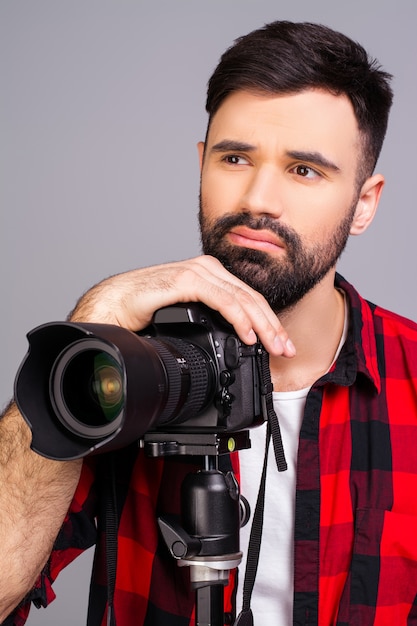 Retrato de hombre triste con cámara pensando en concepto de fotografía