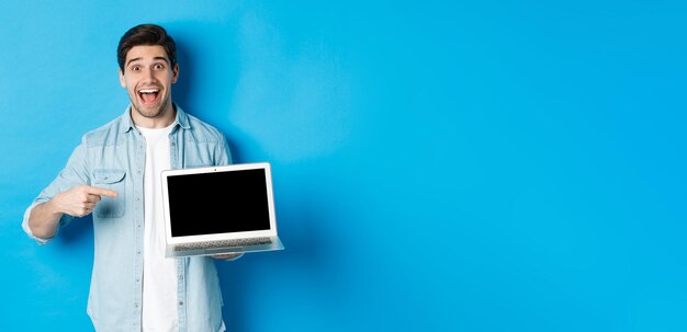 Foto retrato de un hombre usando una tableta digital contra un fondo azul