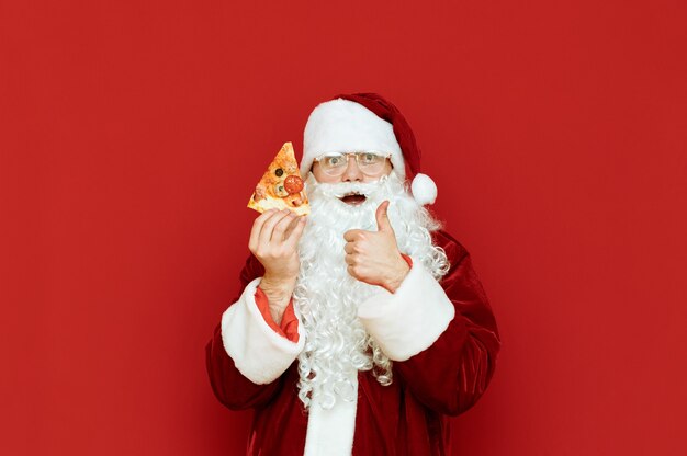 Retrato hombre vestido como Santa Claus sosteniendo pizza