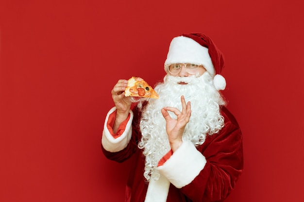 Retrato hombre vestido como Santa Claus sosteniendo pizza