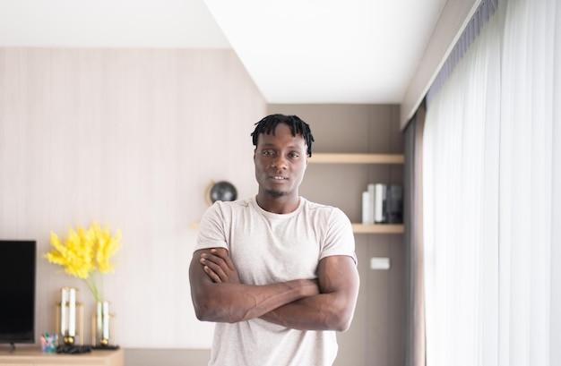 Foto retrato de hombres africanos cruzan los brazos y de pie mirando a la cámara en casa