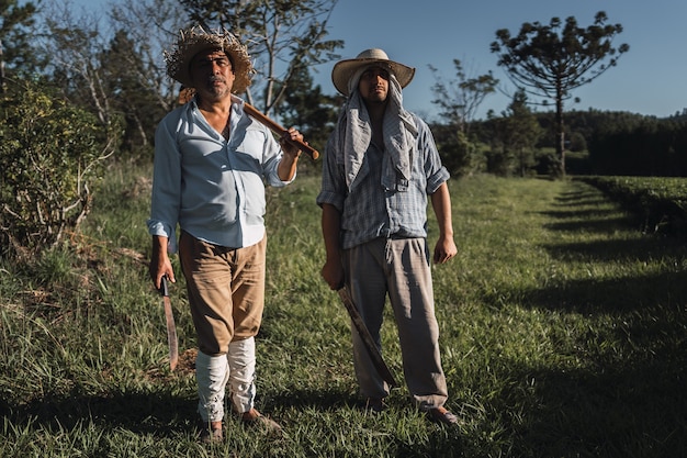 Retrato de hombres maduros trabajando en la tierra con una azada.