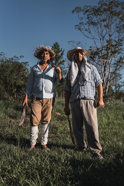 Retrato de hombres maduros trabajando en la tierra con una azada.