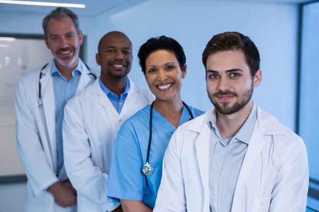 Retrato de hombres médicos y enfermeras de pie en el pasillo