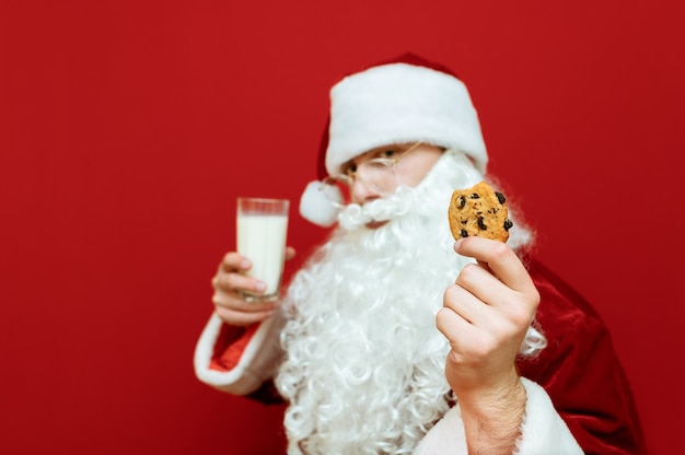 Retrato homem vestido de papai noel comendo chocolate