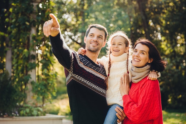 Retrato horizontal de família afetuosa passam o tempo livre juntos desfrutam de uma atmosfera calma pais afetuosos brincam com seu filho pequeno passam o fim de semana ao ar livre conceito de relacionamento