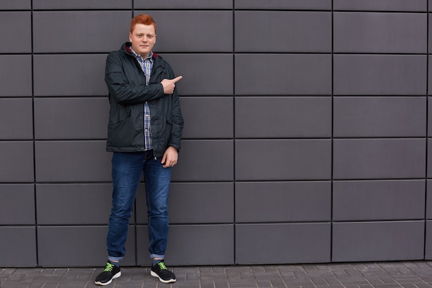 Un retrato horizontal del hombre pelirrojo elegante vestido con camisa a cuadros chaqueta negra jeans