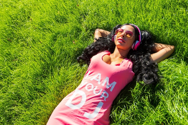 Foto retrato horizontal de una linda estudiante que pasa el día en el parque y muestra el pulgar hacia arriba alegre joven disfrutando del tiempo en el país concepto de fin de semana y vacaciones