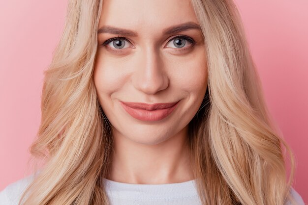 Retrato de una impresionante rubia linda dama mirada cámara sonrisa sobre fondo rosa