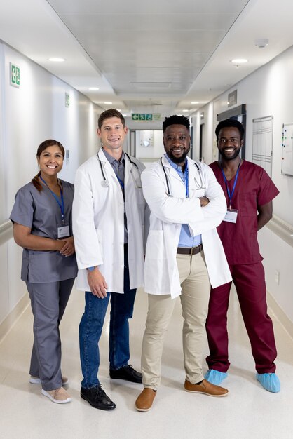 Foto retrato inalterado de um grupo diversificado de médicos sorridentes de pé no corredor do hospital, espaço de cópia