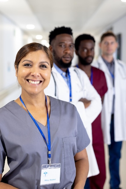 Foto retrato inalterado de uma médica asiática sorridente e vários colegas do sexo masculino no corredor do hospital