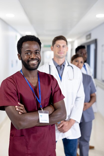Retrato inalterado de un doctor afroamericano sonriente y varios colegas en el hospital