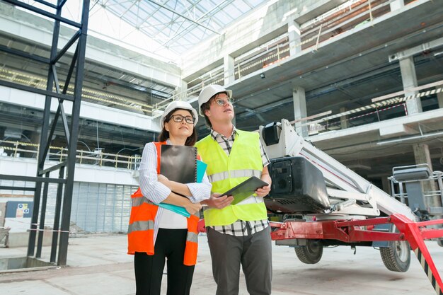 Retrato industrial de engenheiros e engenheiros na construção de prédio administrativo comercial