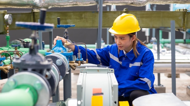 Retrato de una ingeniera profesional segura de sí misma con uniforme de seguridad y casco duro en la azotea del lugar de trabajo de la fábrica industrial