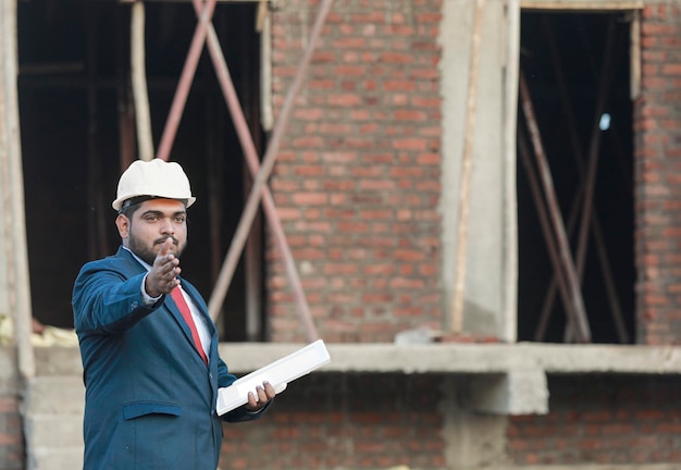 Foto retrato de un ingeniero civil con uniforme de seguridad trabajando en un sitio de construcción