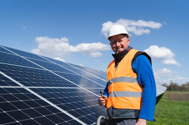 Retrato de ingeniero eléctrico con llave en planta de energía solar