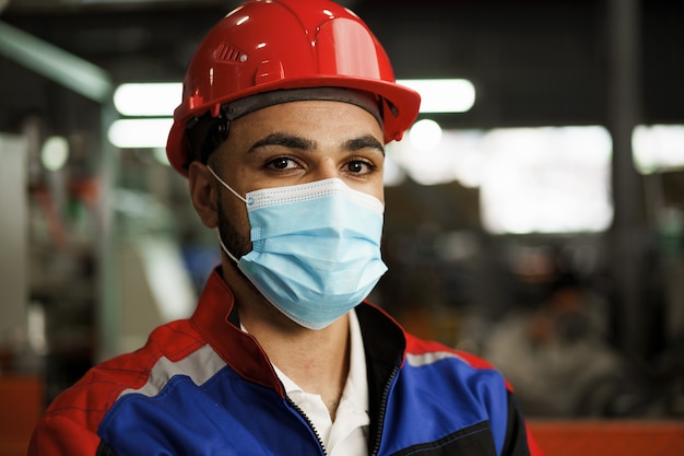 Retrato de un ingeniero de fábrica macho negro con máscara protectora